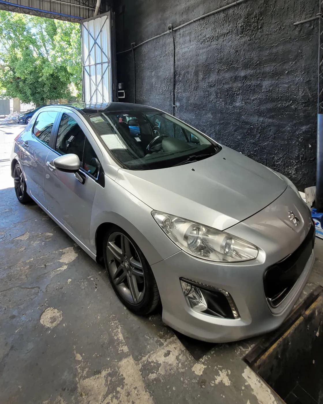 Peugeot 308 gris dentro del taller durante un trabajo de suspensión